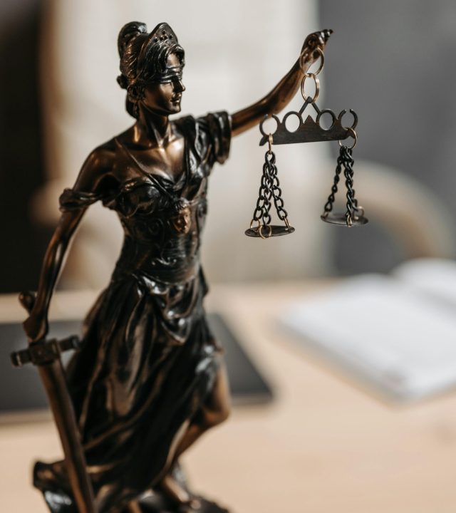Bronze Lady Justice statue with scales and sword, symbolizing fairness and law.